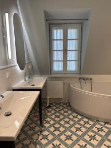 a bathroom with two sinks and a bath tub at Apartament Kirkor przy Dworku Bielin in Bielin