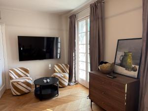 a living room with a tv and a table and chairs at Apartament Kirkor przy Dworku Bielin in Bielin
