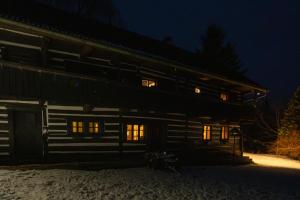 a log cabin at night with the lights on at Pod jednou střechou in Libošovice