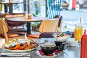 a table with a plate of food and a cup of coffee at STG Hotel Oxford Street - formerly St Giles London Hotel in London +57 photos