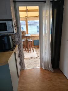 a kitchen with a door open to a dining room at Mobile home in Quimper