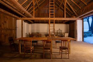 a large wooden table and chairs in a barn at Pod jednou střechou in Libošovice
