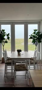 a dining room with a white table and chairs at HaRe Ferienwohnungen in Langeneß