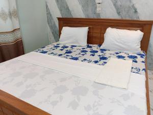 a bed with blue and white sheets and pillows at Guest House ETE-D Plus in Bohicon