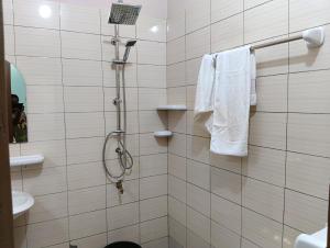 a bathroom with a shower with white towels at Guest House ETE-D Plus in Bohicon +14 photos