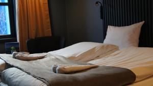 a bed with two pillows and a blanket on it at Marina Hotel Sortland in Sortland