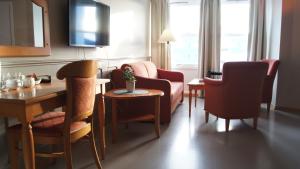 a living room with chairs and a table and a room at Marina Hotel Sortland in Sortland