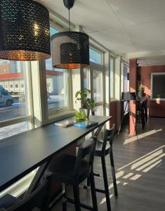 a dining room with a table and chairs and lights at Marina Hotel Sortland in Sortland