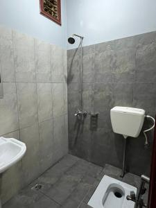 a bathroom with a shower and a toilet and a sink at Qaiser Hotel in Lahore