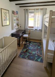 a bedroom with two bunk beds and a desk at Ferienwohnung am Badesee in Arrach