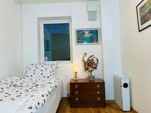 a bedroom with a bed and a dresser and a window at COZY ROOM in Helsingborg in Helsingborg