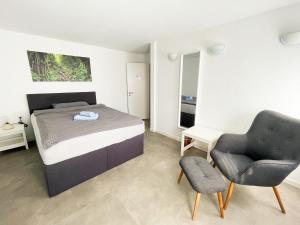 a bedroom with a bed and a chair at Modern Apartment Wissenbach 1 in Eschenburg