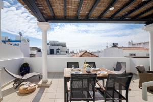 a patio with a table and chairs on a balcony at Ria's Birds in Cabanas de Tavira