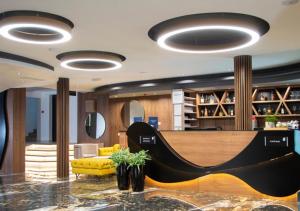 a hotel lobby with a yellow couch and a table at Hotel Biga in Zavidovići