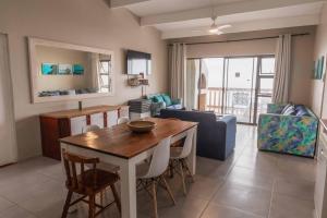 a dining room and living room with a table and chairs at Mitford-on-Sea in Morganʼs Bay