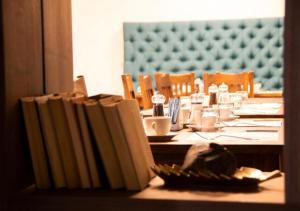 a table with books on top of a table with a tableablish at Hotel Biga in Zavidovići