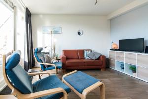 a living room with a couch and two chairs at Vleijenhof Type C in Buren