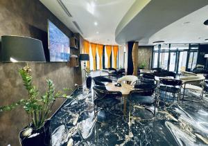 a lobby with a table and chairs in a room at Hotel Biga in Zavidovići