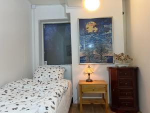 a bedroom with a bed and a dresser and a painting at COZY ROOM in Helsingborg in Helsingborg +6 photos