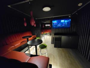 a bar with a couch and a tv and chairs at Hotelli Savonlinna in Savonlinna