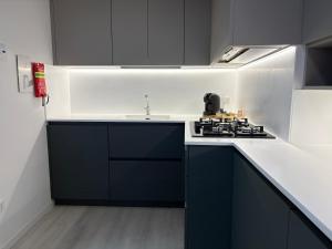 a kitchen with black and white cabinets and a stove at The Desdemona in Pordenone