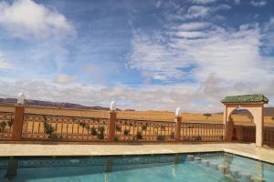 a pool on a fence with a view of the desert at Ouzina Desert Camp in Ouzina