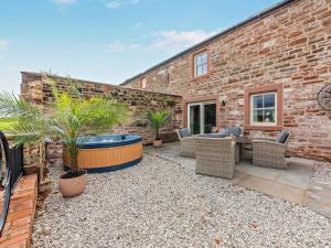 a patio with a hot tub in a brick building at 2 Bed in Carlisle oc-96302 in Scaleby