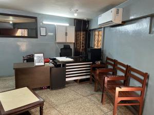 a room with chairs and a table and a kitchen at Qaiser Hotel in Lahore