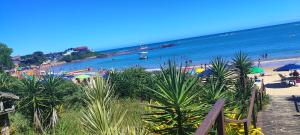 a view of a beach with people and the ocean at pousada peracanga in Guarapari