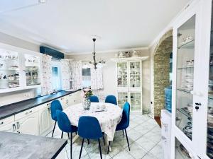 a kitchen with a table and blue chairs at Nirvana Apartman in Balatonberény
