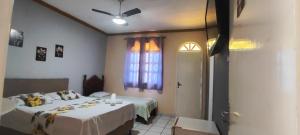 a bedroom with two beds and a window at pousada peracanga in Guarapari