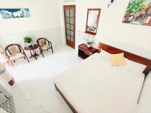 a bedroom with a bed and a table and chairs at holtel Tâm An in Da Lat