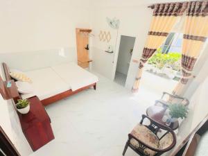 a small room with a bed and a chair at holtel Tâm An in Da Lat +17 photos