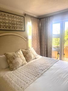 a bedroom with a white bed with a window at The Gables Boutique Hotel in Chintsa