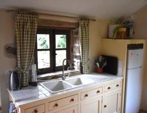 a kitchen with a sink and a window at Gîte Léon, Beynat, Corrèze in Beynat