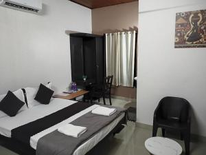 a bedroom with a bed and a desk with a chair at Baywatch Beach Resort in Alleppey