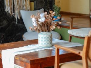 a table with a vase with flowers on it at Posada Quellen in Villa General Belgrano