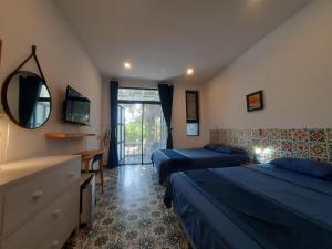 a bedroom with two beds and a desk and a mirror at H2B Homestay Mountains view near Bai Dai Beach in Cam Lâm