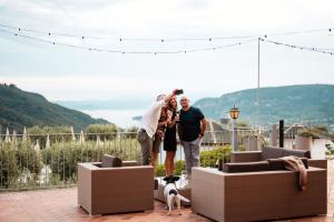 a group of three people and a dog on a patio at Hotel Boffenigo - The Golden Hour in Costermano