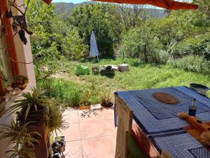 a patio with a table and a view of a garden at Bird cottage in Barrydale