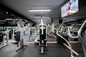 a gym with lots of treadmills and machines at Sheraton Khalidiya Hotel in Abu Dhabi