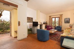 a living room with a couch and a tv at Valdichiana Panorama Villa - Private Pool in Marciano