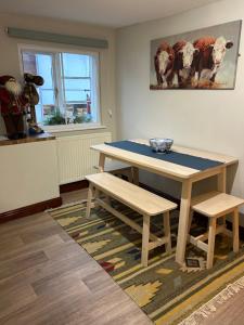 a dining room with a table and two benches at The Old Post Office in Bridgnorth