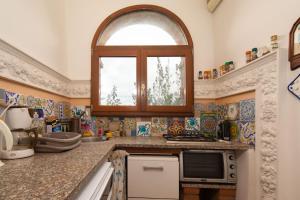 a kitchen with an arched window and a counter top at Valdichiana Panorama Villa - Private Pool in Marciano