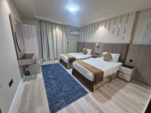 a hotel room with two beds and a blue rug at درة رواق للشقق المخدومة - Durrat Rwaq Serviced Apartments in Riyadh +34 photos