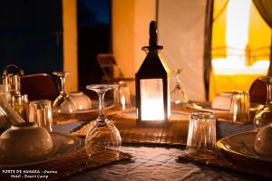 a table topped with glasses and a lantern on a table at Ouzina Desert Camp in Ouzina +63 photos