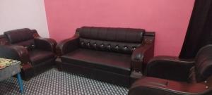 a waiting room with a bench and a pink wall at Gyan Homestay in Bareilly