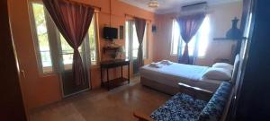 a bedroom with a bed and a couch and windows at Haluk Otel in Milas