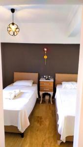 a bedroom with two beds and a night stand with a table at Haluk Otel in Milas +1 photo