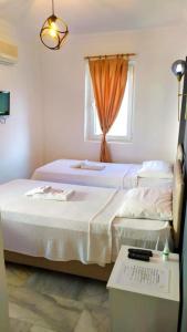 a white bedroom with a bed and a window at Haluk Otel in Milas